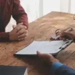 Legal counsel presenting a signed contract to a client