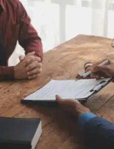Legal counsel presenting a signed contract to a client